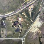 Aerial view of Aledo, TX, showing roads and scattered houses near 2301 FM 1187. Major roads intersect, with buildings clustered at the bottom left and open fields, a pond, and trees expanding to the right.