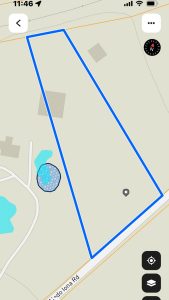 A digital map displays a large, irregular, blue-outlined plot of land at 2301 FM 1187 in Aledo, TX, bordered by two roads. Pale shapes indicate buildings and small ponds within and near the outlined area. Map icons are visible.