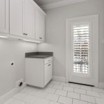 A clean, modern laundry room with white cabinets, white tile floor, a small countertop, and a door with white shutters letting in natural light. There are wall outlets and hookups for laundry appliances.