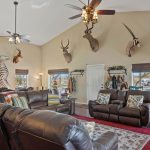 A living room with leather couches and a ceiling fan.
